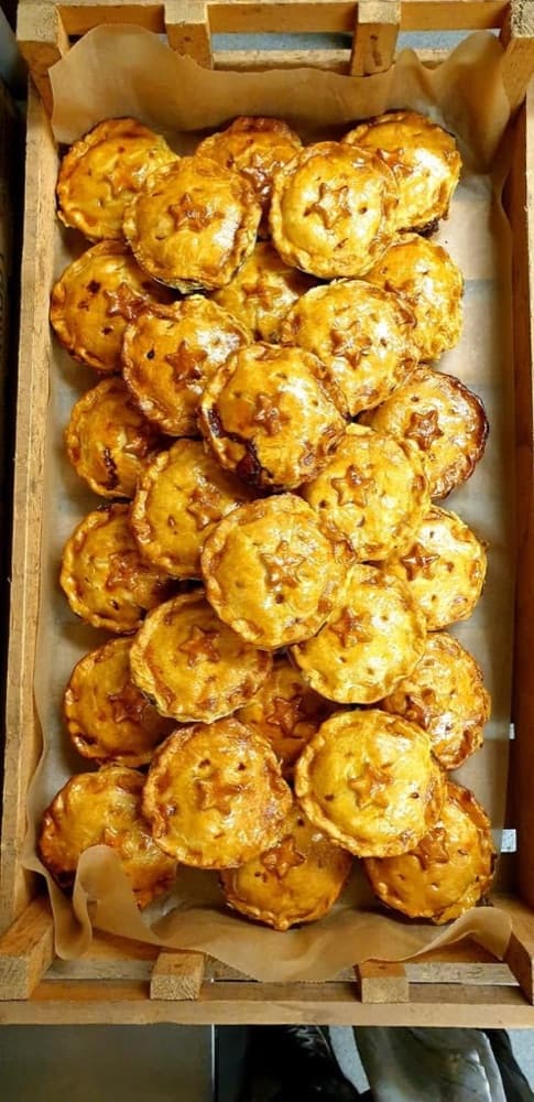 Wooden crate of golden star-topped savoury pies lined with parchment